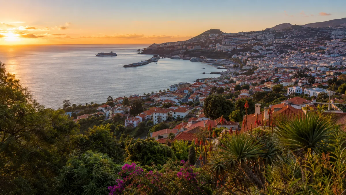 La bahía y el puerto de Funchal al atardecer vistos desde las alturas de Monte, con un crucero atracado y la ciudad trepando por la ladera verde
