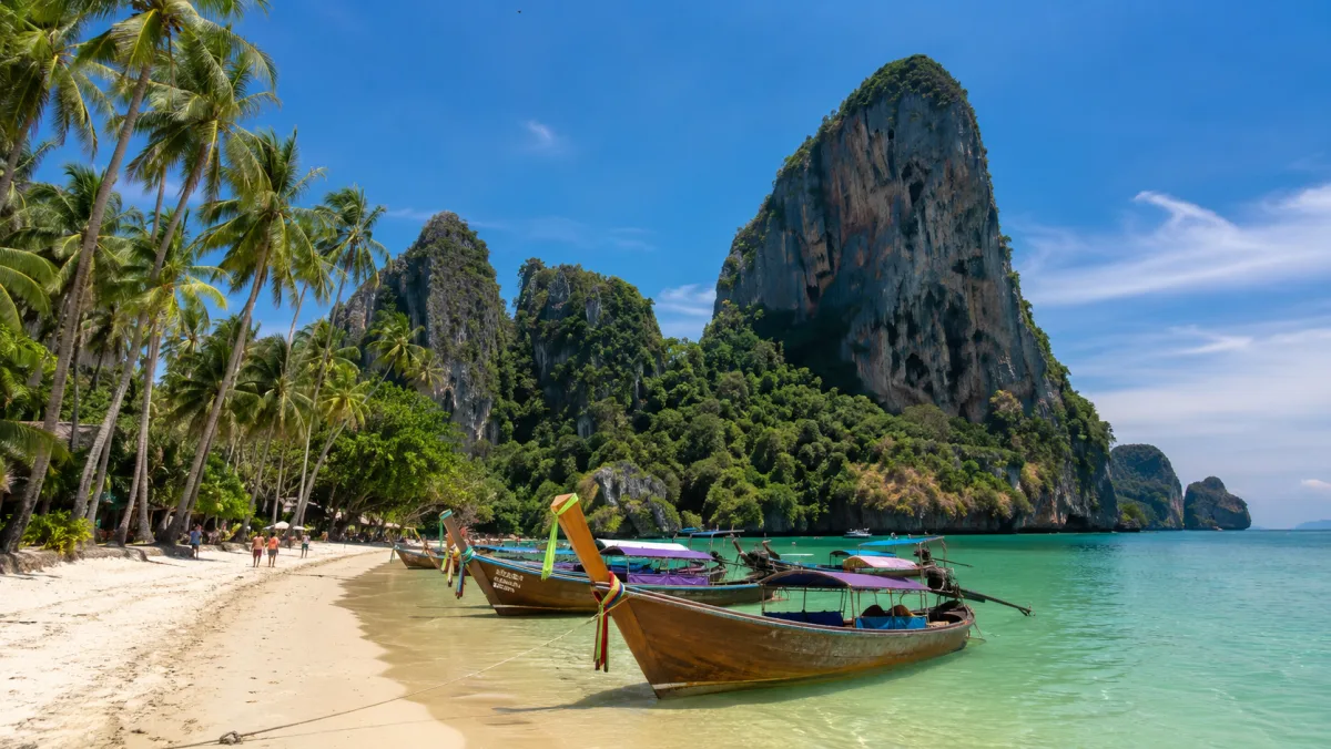 Acantilados calizos de Railay o Koh Phi Phi sobre un mar turquesa con barcas long-tail tradicionales