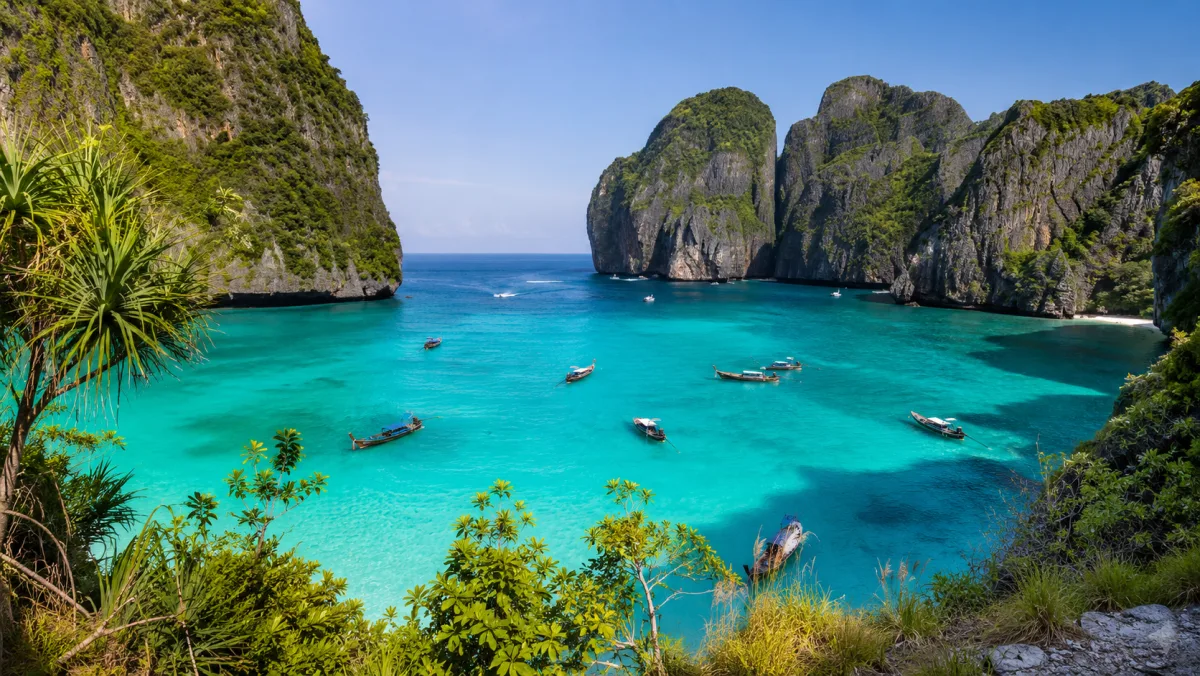 Playa de Railay o Koh Phi Phi con barcas long-tail en aguas turquesa y acantilados calizos