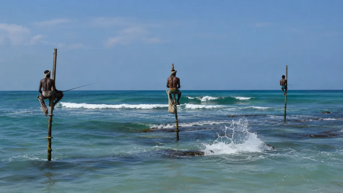 Pescadores tradicionales en zancos sobre el mar turquesa de la costa sur de Sri Lanka, con un surfista cogiendo una ola al fondo